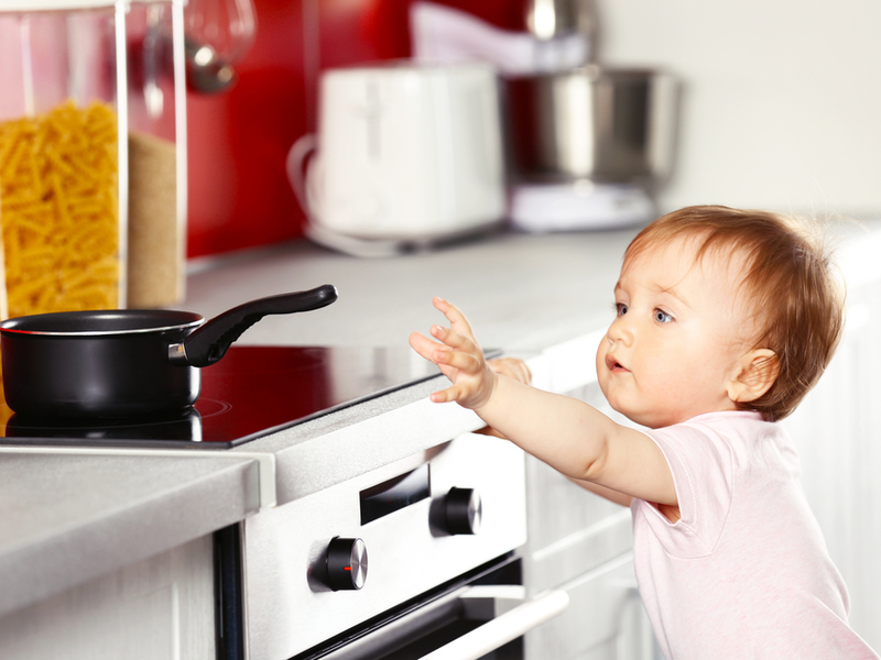 Dijete pokušava dohvatiti lonac na štednjaku